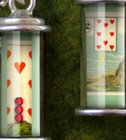 Shadowbox Glass Tube Pendants are handmade miniature dioramas encased in a glass tube and hung from a chain.